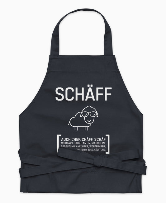 Nahaufnahme der dunkelblauen SCHÄFF – Chef Schürze Classic mit ikonischem Schaf und lustigem Text im Wörterbuchstil.