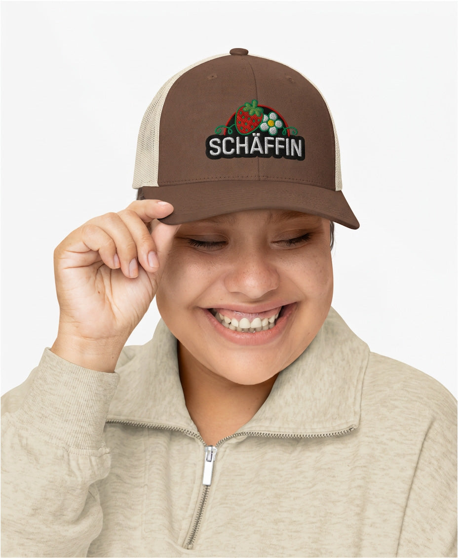 Modell mit SCHÄFFIN Retro Trucker Cap Erdbeere, in Braun-Khaki mit hochwertigem Erdbeer-Stickerei-Motiv, Frontansicht