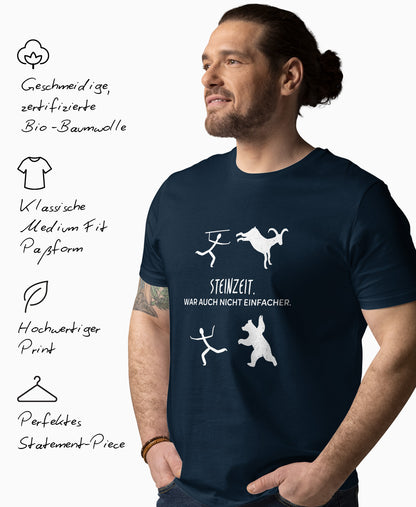 Mann trägt navyfarbenes Bio-T-Shirt mit weissem SCHÄFF Motiv einer Höhlenmalerei und dem Text: Steinzeit war auch nicht einfacher. Links daneben Produktmerkmale: geschmeidige Bio-Baumwolle, Medium Fit Passform, hochwertiger Print und perfektes Statement-Piece.