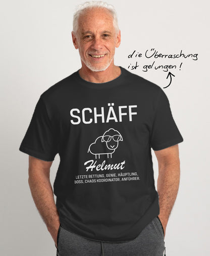 Mann im schwarzen T-Shirt mit großem Schriftzug SCHÄFF Helmut und Schaf mit Sonnenbrille; daneben der Hinweis ‚die Überraschung ist gelungen !’