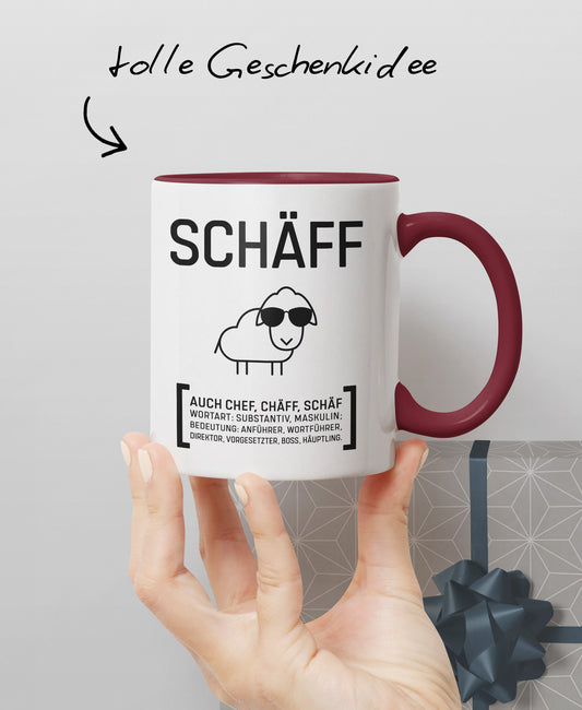 Hand präsentiert zweifarbige Keramiktasse mit SCHÄFF Motiv: cooles Schaf mit Sonnenbrille – und Hinweis ‚tolle Geschenkidee’.