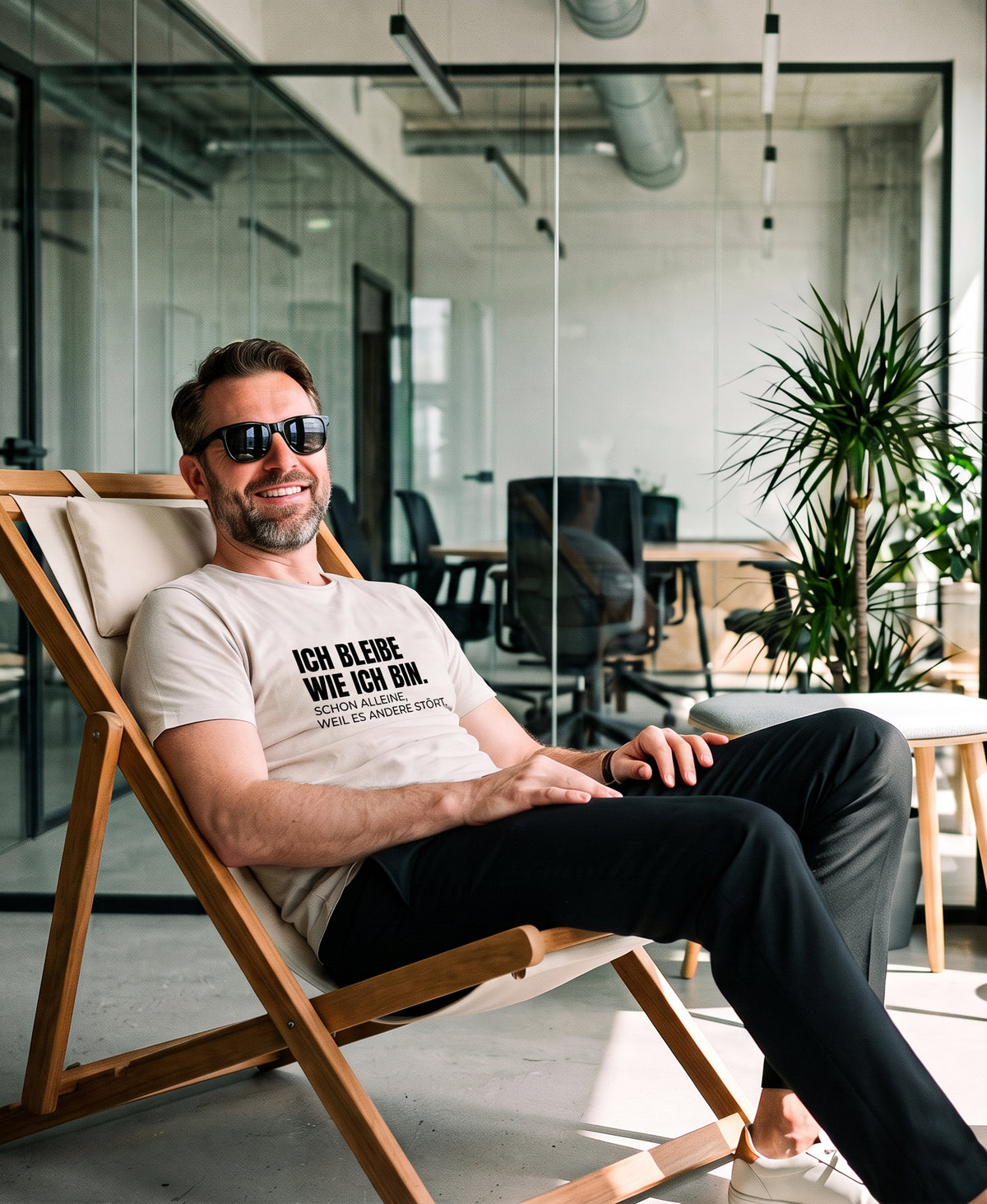 Mann mit Sonnenbrille im modernen Büro im Liegestuhl mit SCHÄFF – Ich bleibe wie ich bin – Lustiges Spruch T-Shirt mit Text.