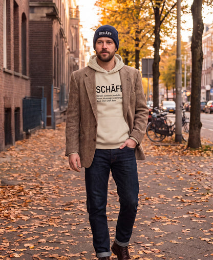 Chef auf dem Weg zur Arbeit, mit  Sakko, SCHÄFF Beanie in Navy und SCHÄFF – Chef Definition Bio-Hoodie in Desert Dust