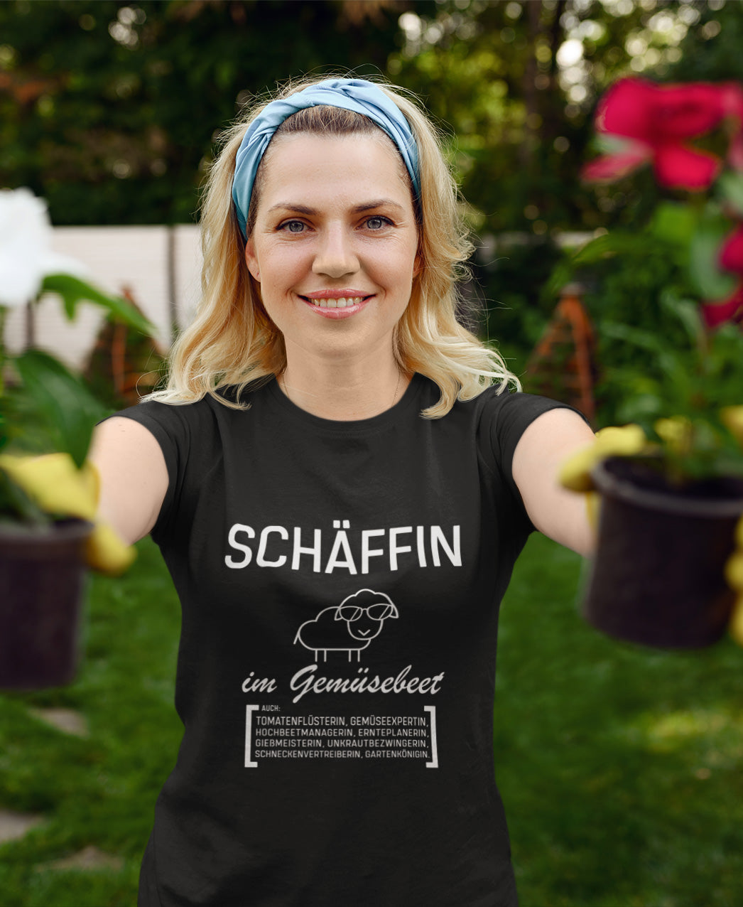 Frau trägt schwarzes SCHÄFFIN – Gärtnerin Garten Bio T-Shirt im Garten beim Pflanzen. Lustiges Gärtnerin T-Shirt mit Text wie aus dem Wörterbuch.