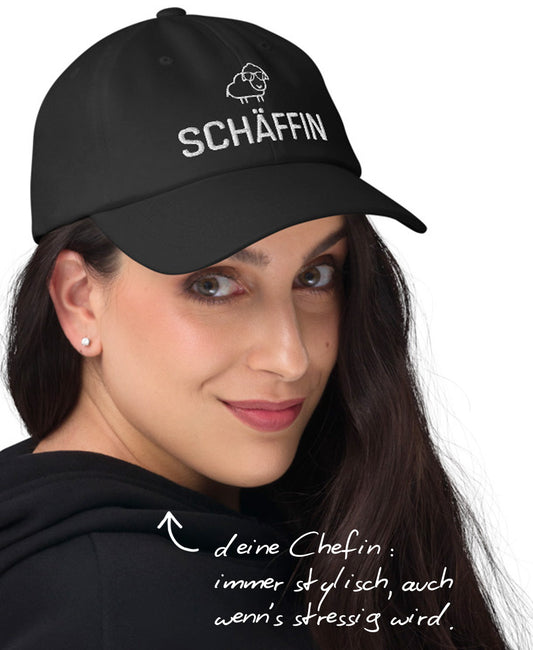 Frau mit schwarzer Schäffin Cap und Hinweis: ‚deine Chefin: immer stylisch, auch wenn’s stressig wird.’
