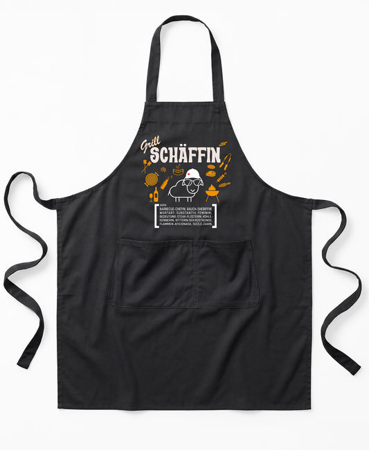 Schwarze Premium SCHÄFFIN – Grill Chefin Schürze aus Bio-Baumwolle mit witzigem Wörterbuch-Design und zwei großen Vordertaschen.