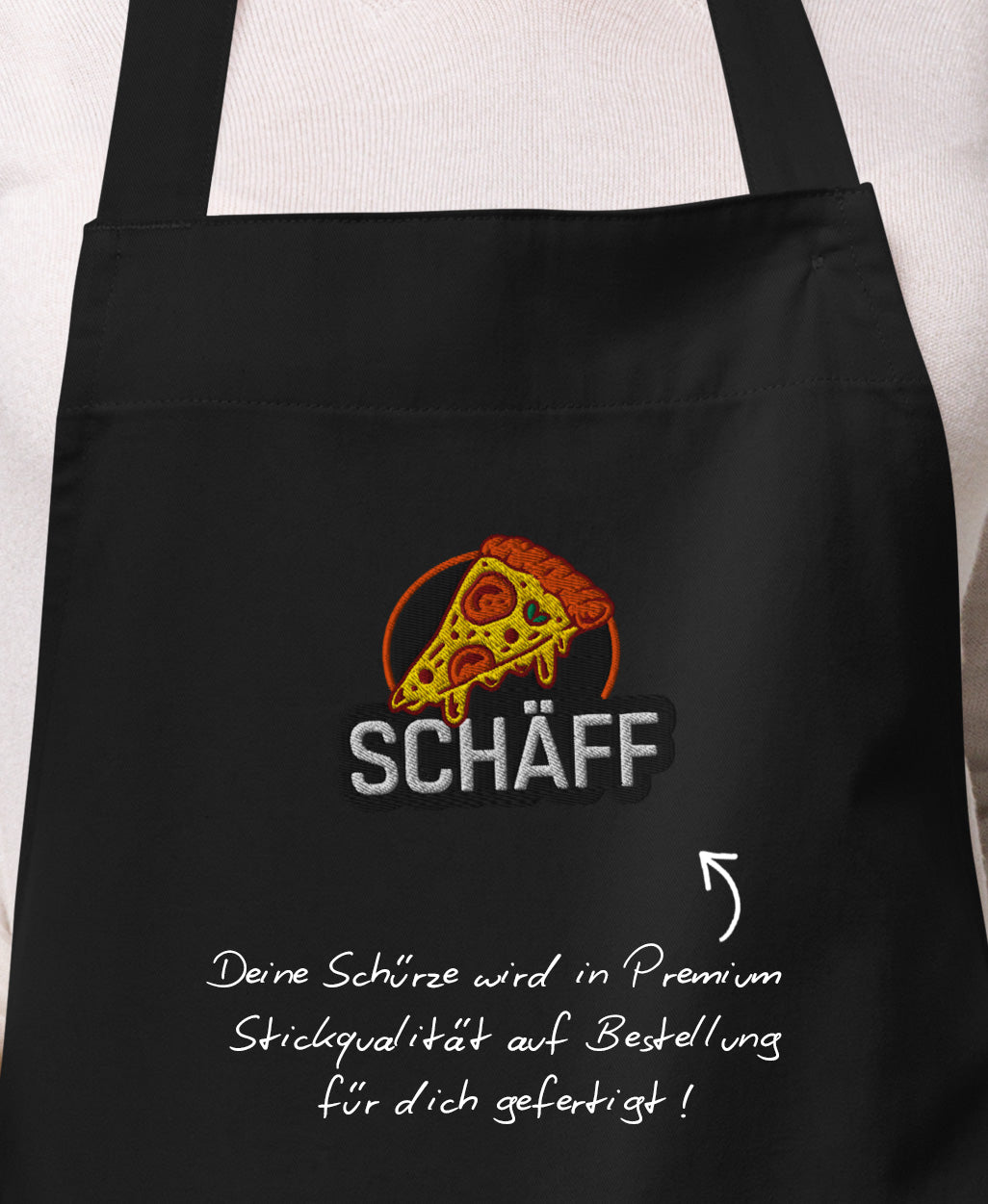 Nahaufnahme der hochwertigen, detailreichen Pizza-Stickerei mit SCHÄFF Schriftzug auf der schwarzen Bio-Baumwoll-Schürze.