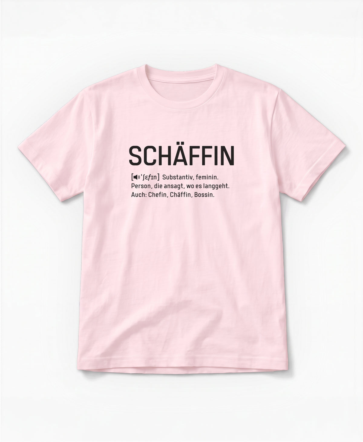 Rosafarbenes T-Shirt mit schwarzem Frontaufdruck im Wörterbuch-Stil: SCHÄFFIN – Substantiv, feminin. Person, die ansagt, wo es langgeht. Auch: Chefin, Chäffin, Bossin.