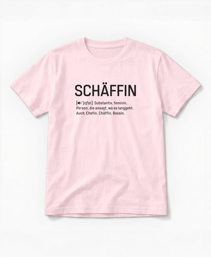 Rosafarbenes T-Shirt mit schwarzem Frontaufdruck im Wörterbuch-Stil: SCHÄFFIN – Substantiv, feminin. Person, die ansagt, wo es langgeht. Auch: Chefin, Chäffin, Bossin.