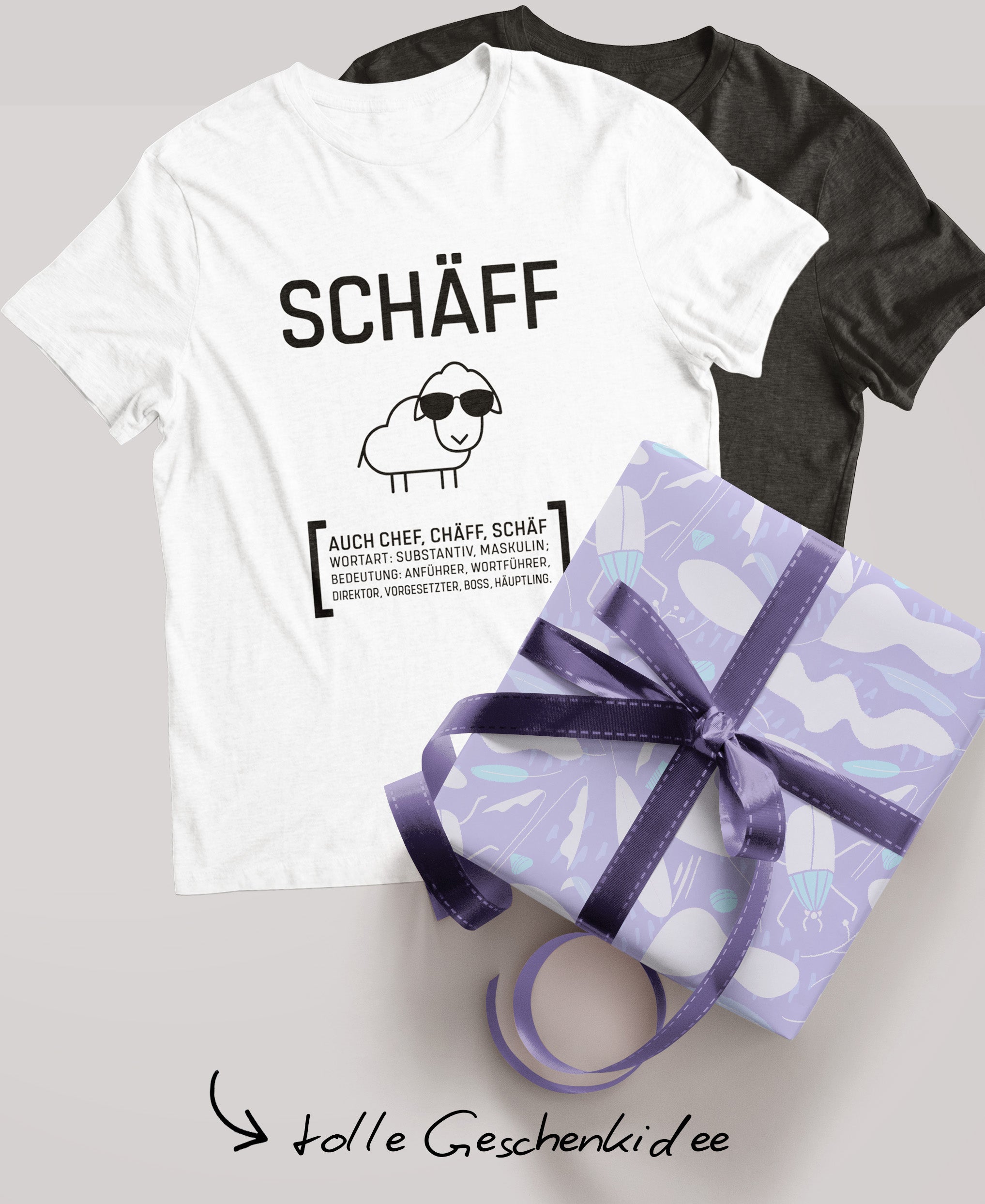 Schwarzes und weisses Schäff T-Shirt; daneben ein verpacktes Geschenk mit lila Schleife und der Schriftzug ‚tolle Geschenkidee‘.