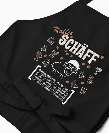 Nahaufnahme der schwarzen Kaffee SCHÄFF Kochschürze mit detailreichem, braun-weißem Aufdruck.
