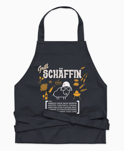 Dunkelblaue Premium Grill SCHÄFFIN Kochschürze aus Bio-Baumwolle mit witzigem Wörterbuch-Design und zwei großen Vordertaschen auf weißem Hintergrund.