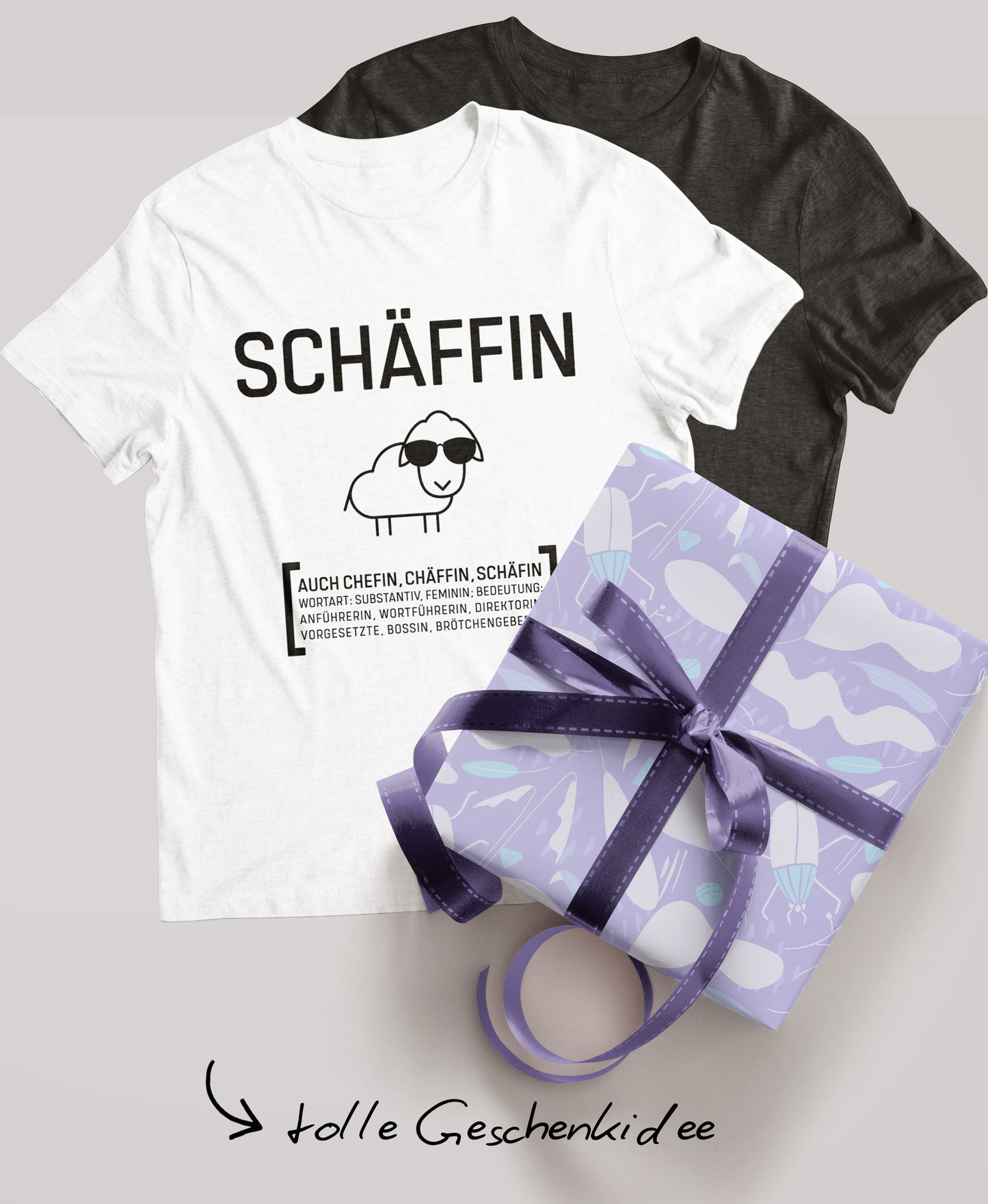Schwarzes und weisses Schäffin T-Shirt; daneben ein verpacktes Geschenk mit lila Schleife und der Schriftzug ‚tolle Geschenkidee‘.
