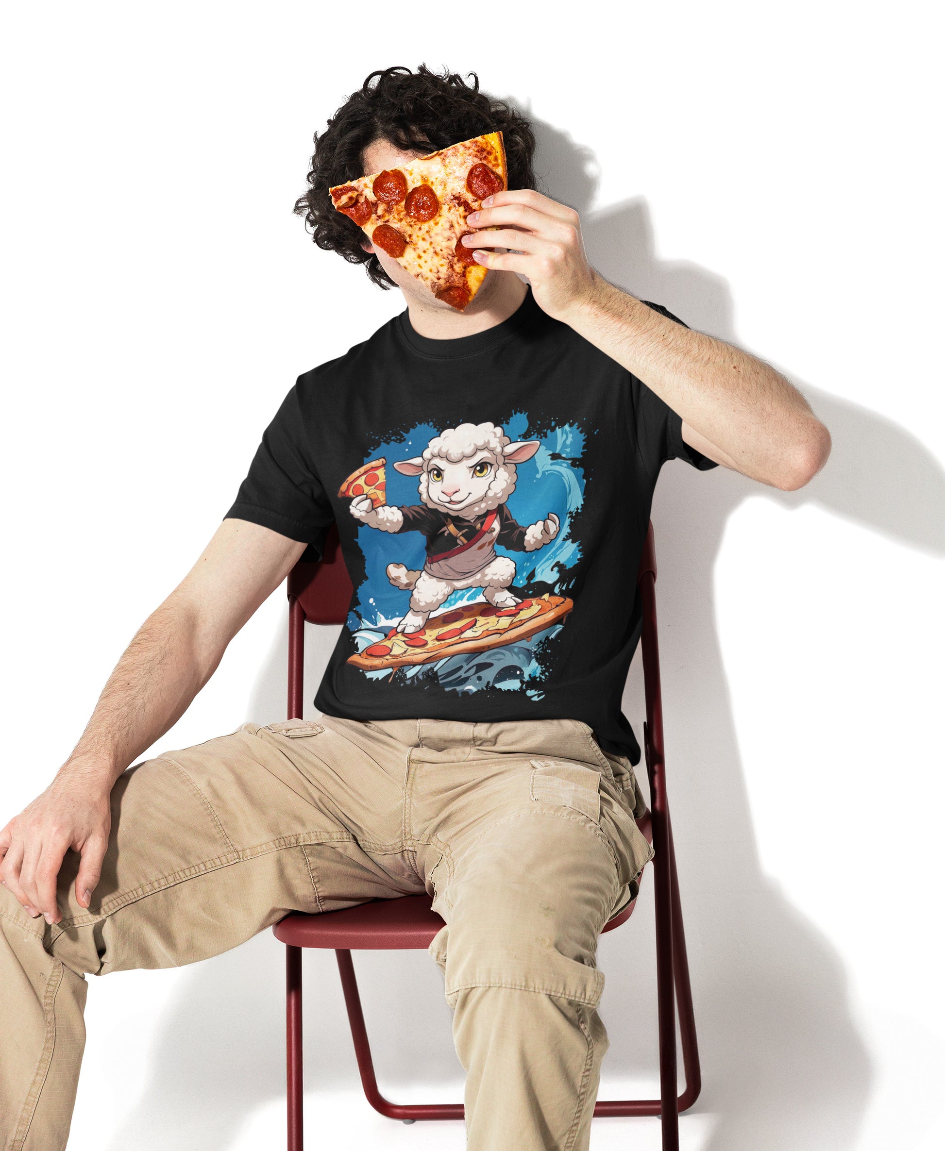 Model in einem schwarzen SCHÄFF Bio T-Shirt, das ein Pizzastück vor sein Gesicht hält. Das Shirt zeigt eine Grafik eines Schafs, das auf einer Pizza surft. Lässiges Outfit mit Cargohose und Pizza-Vibe.