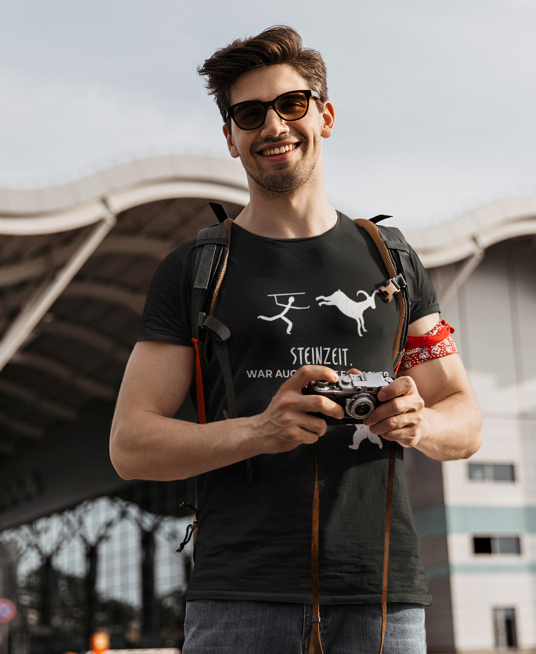 Mann mit Sonnenbrille und Fotoapparat trägt das lustige SCHÄFF – Steinzeit war auch nicht einfacher - Bio T-Shirt